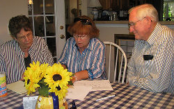 Sandra and Don Humphrey look on as Suzi Stephens of the Malawi Project, goes over the list of needed supplies and equipment, for the new medical facility.