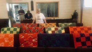 Quilts draped over the pews in a church