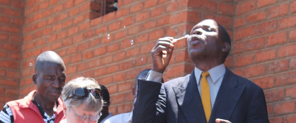 A man blowing bubbles outside of the St. Joseph grain warehouse