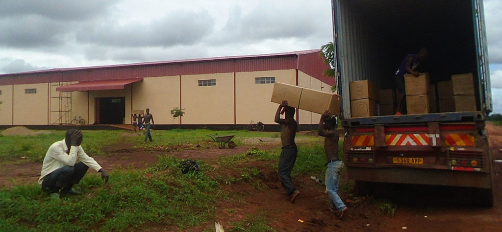 Men carrying boxes into warehouse