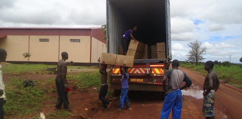 Men unloading supplies from a truck in the rain